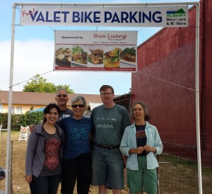 Volunteers Sara, Nick, Sylvia, Ken and Anne beneath the Bua Luang banner after a long & productive day of parking 300+ bikes! Please join them this year!